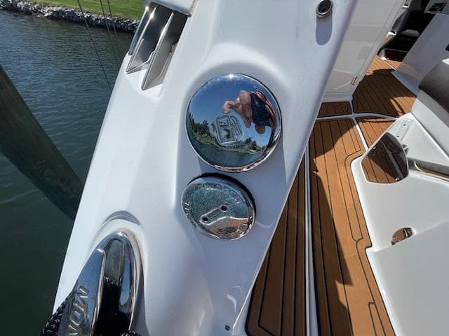 2019 Monterey 295 boat deck with chrome fixtures and teak flooring by the water.