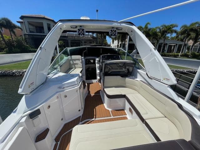 2019 Monterey 295 boat interior with spacious seating and modern design, docked near waterfront homes.