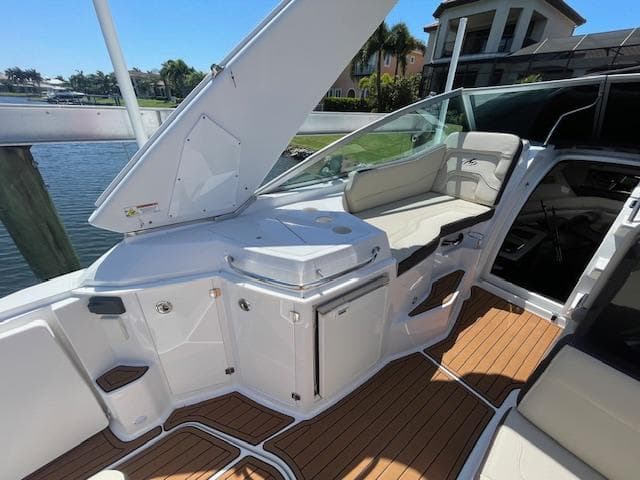 2019 Monterey 295 boat interior with seating, open hatch, and wooden deck.