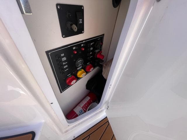 Control panel inside a 2019 Monterey 295 boat, featuring switches and a fire extinguisher.
