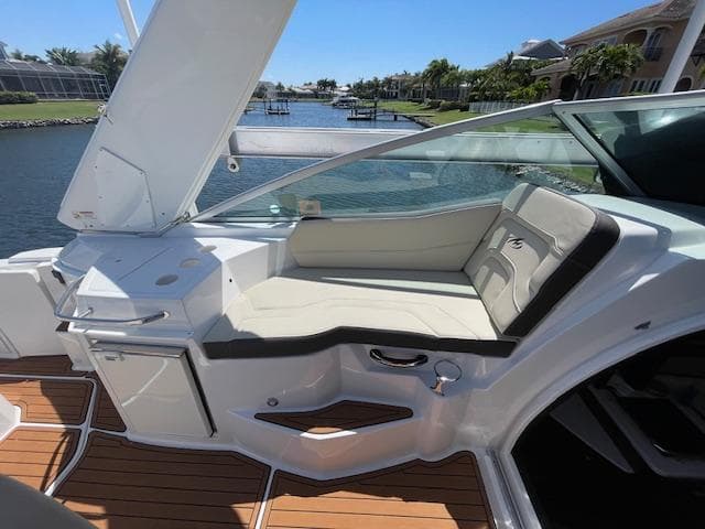 2019 Monterey 295 boat interior with white seating, wooden flooring, and waterfront view.