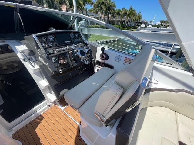 2019 Monterey 295 boat cockpit with steering wheel, control panel, and cushioned seating.