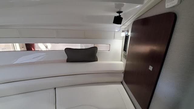 2019 Monterey 295 interior cabin with white seating and dark wood accents.