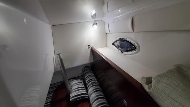 2019 Monterey 295 cabin interior with striped seating and porthole window.