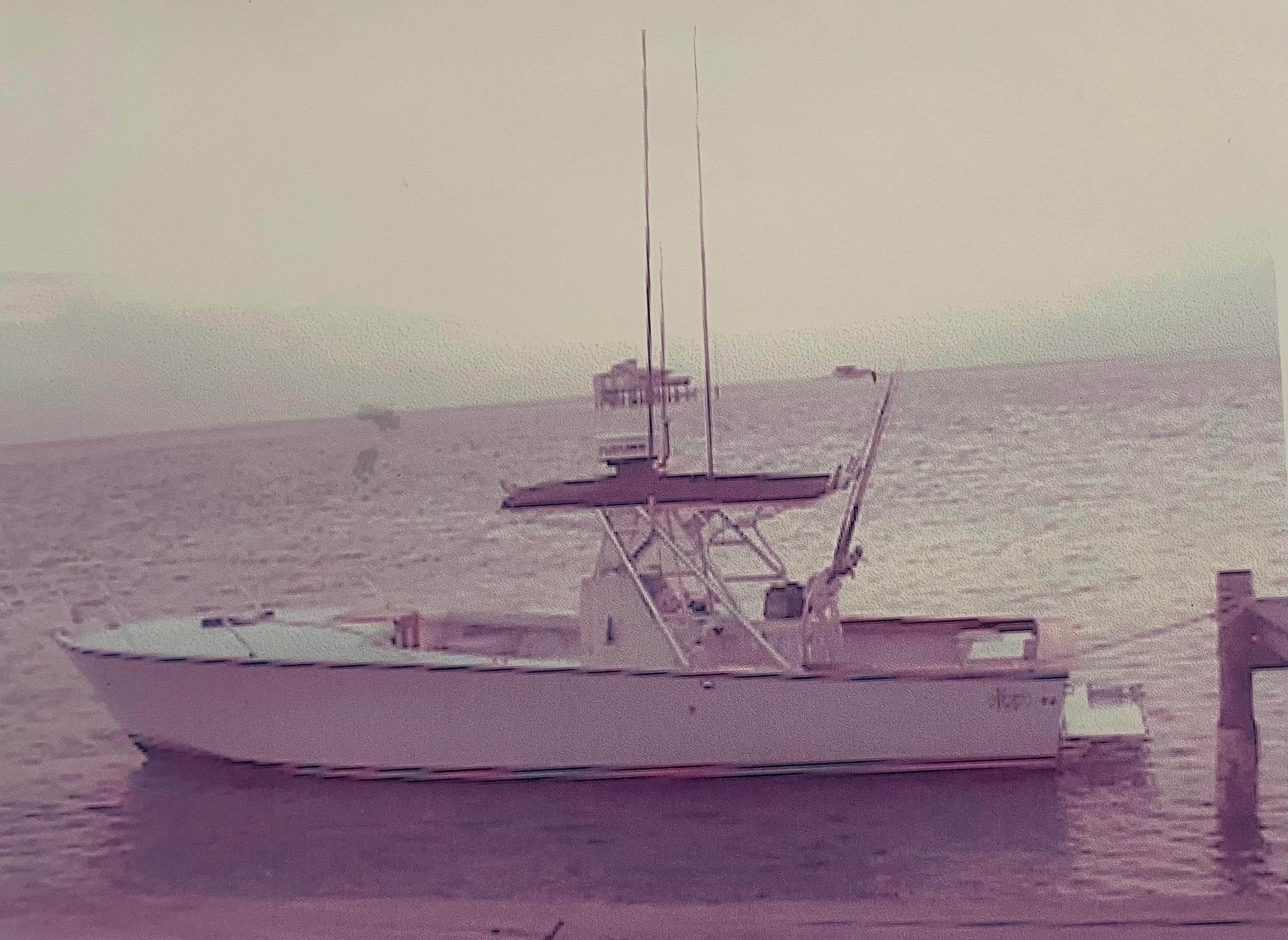 2000 Stuart Angler 32 Center Console boat docked by the sea.