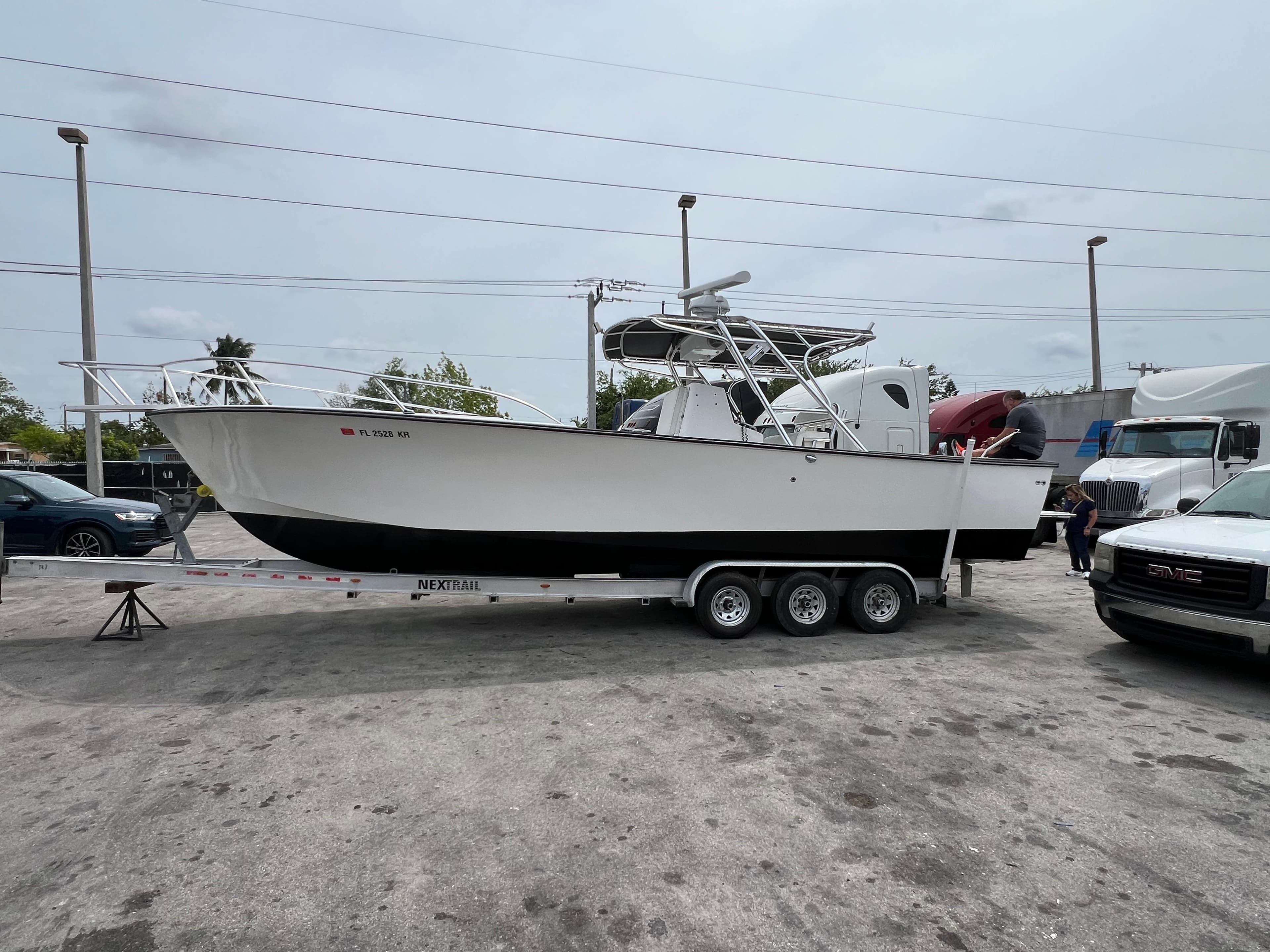 2000 Stuart Angler 32 Center Console boat on trailer in parking lot.
