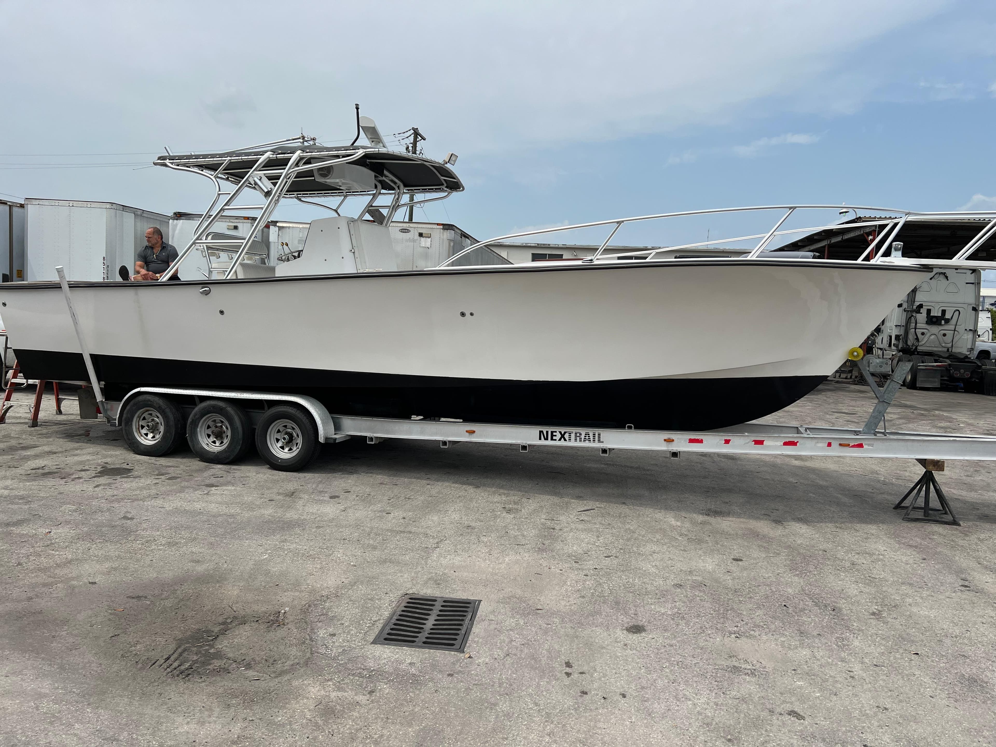 2000 Stuart Angler 32 Center Console/Cutty boat on trailer, parked outdoors.