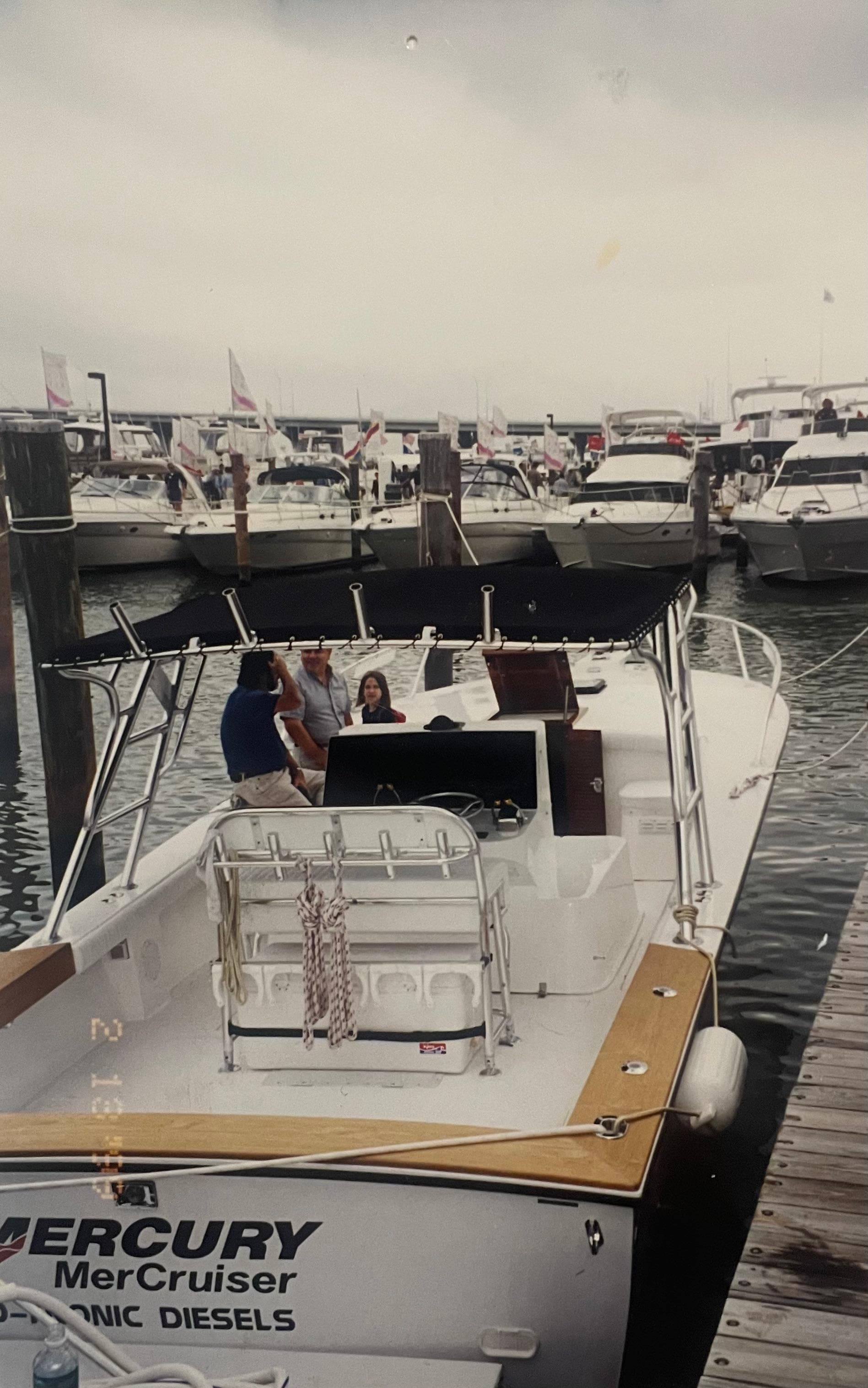 2000 Stuart Angler 32 Center Console boat docked at marina with people onboard.