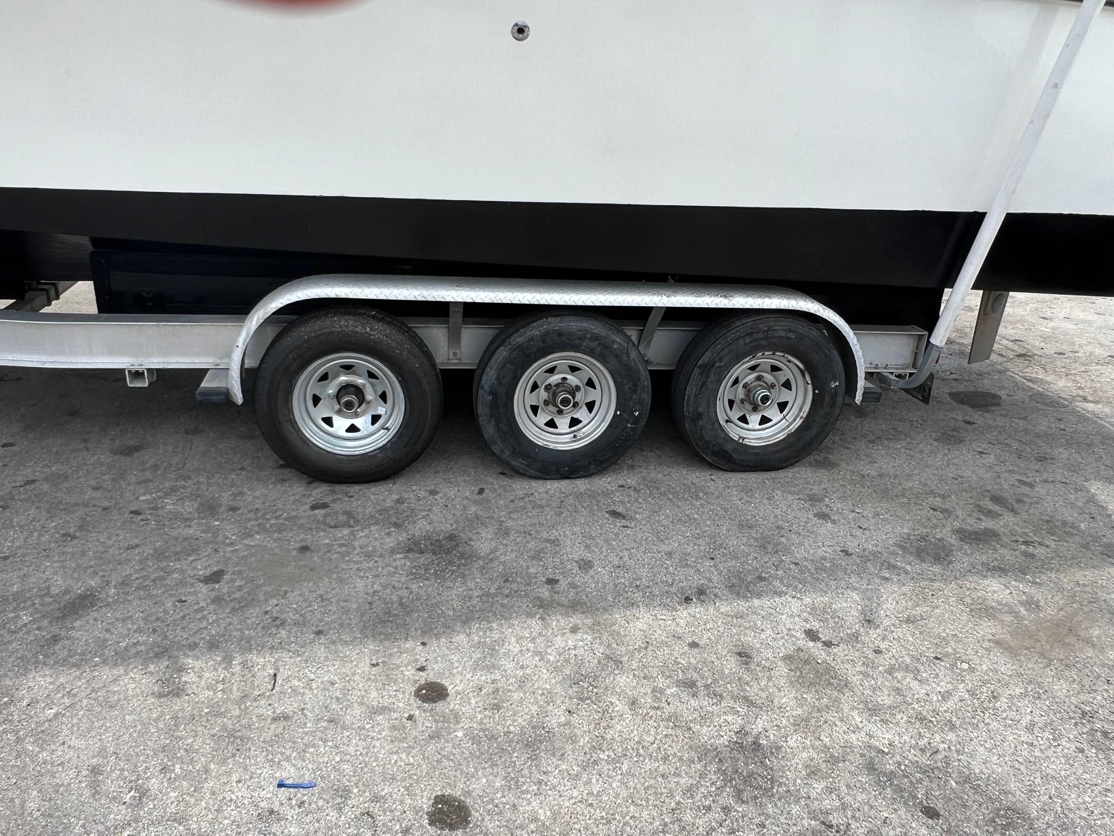 Trailer with triple-axle wheels for 2000 Stuart Angler 32 Center Console/Cutty boat.