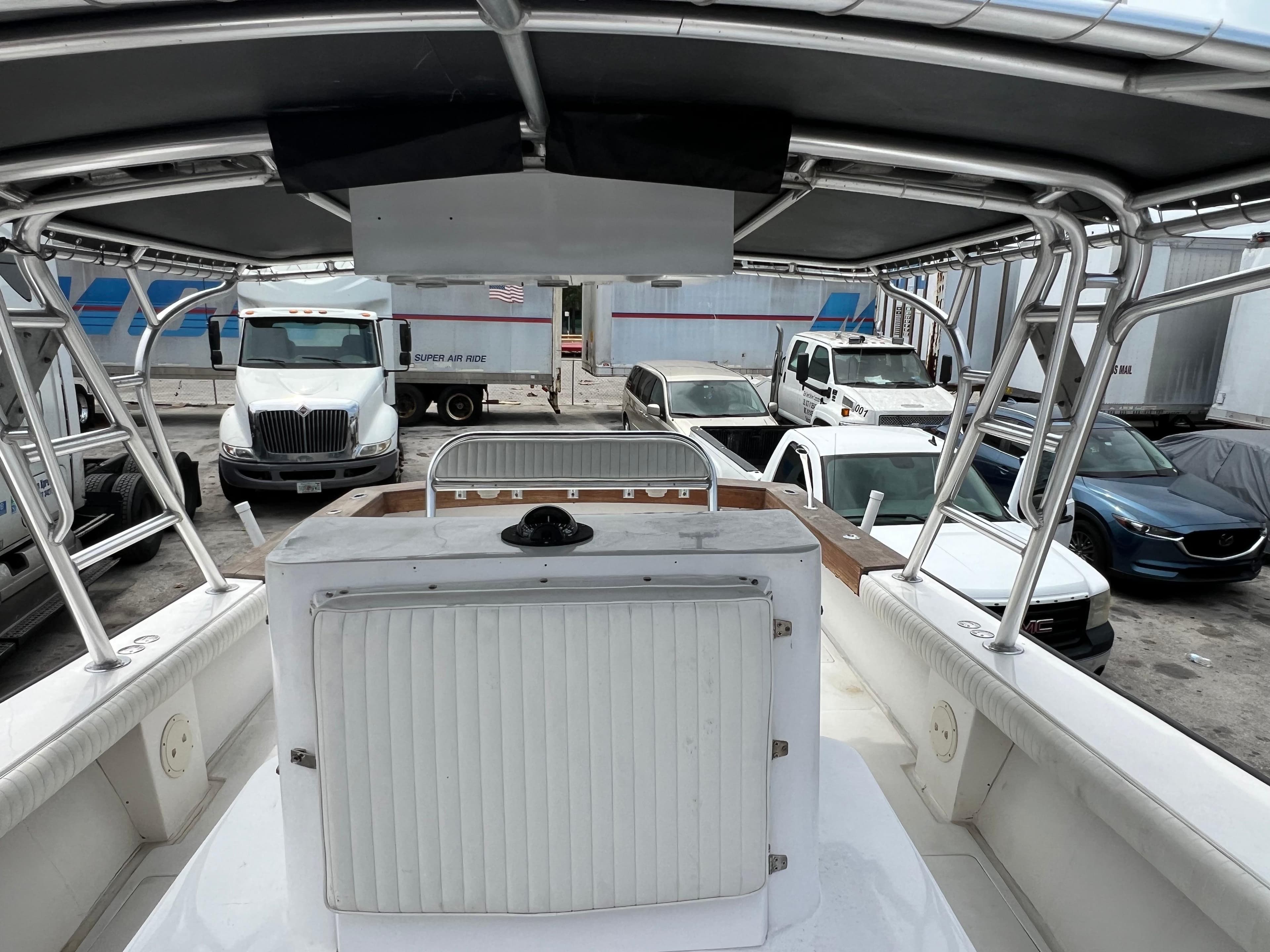 2000 Stuart Angler 32 Center Console boat in a parking lot with trucks and cars.