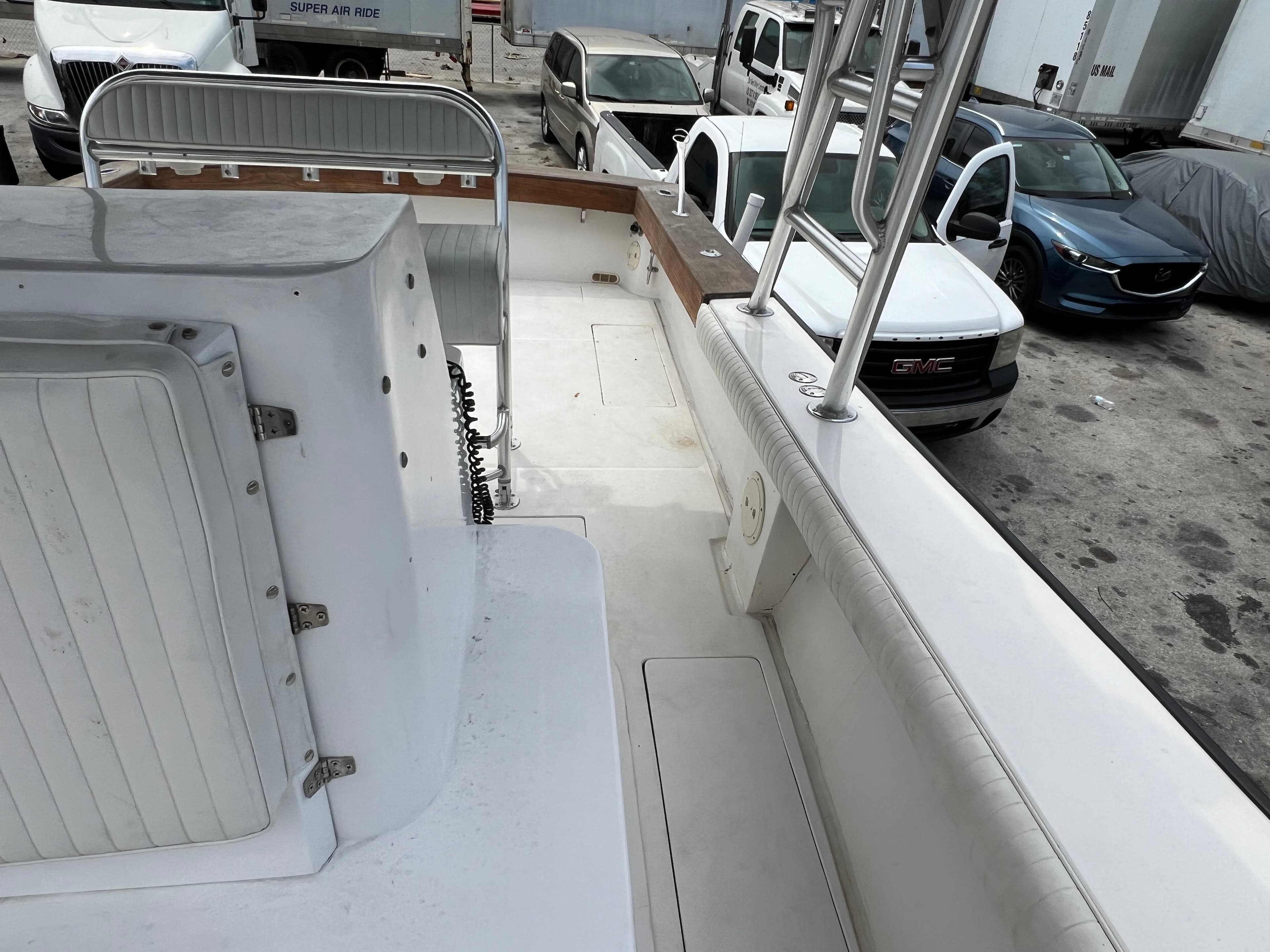 2000 Stuart Angler 32 Center Console boat interior with parked vehicles in background.