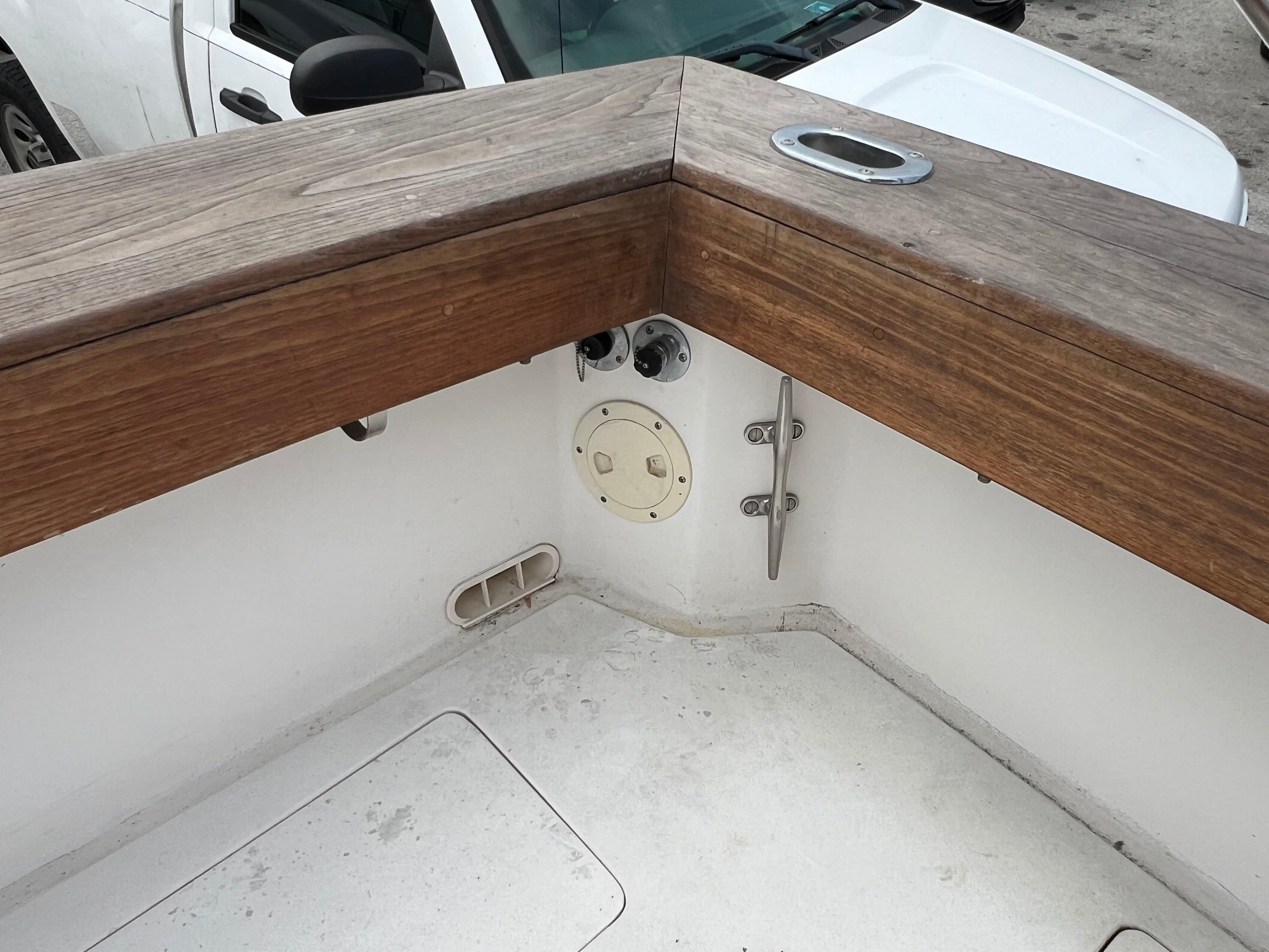 2000 Stuart Angler 32 Center Console/Cutty boat deck with wooden railing and cleat.