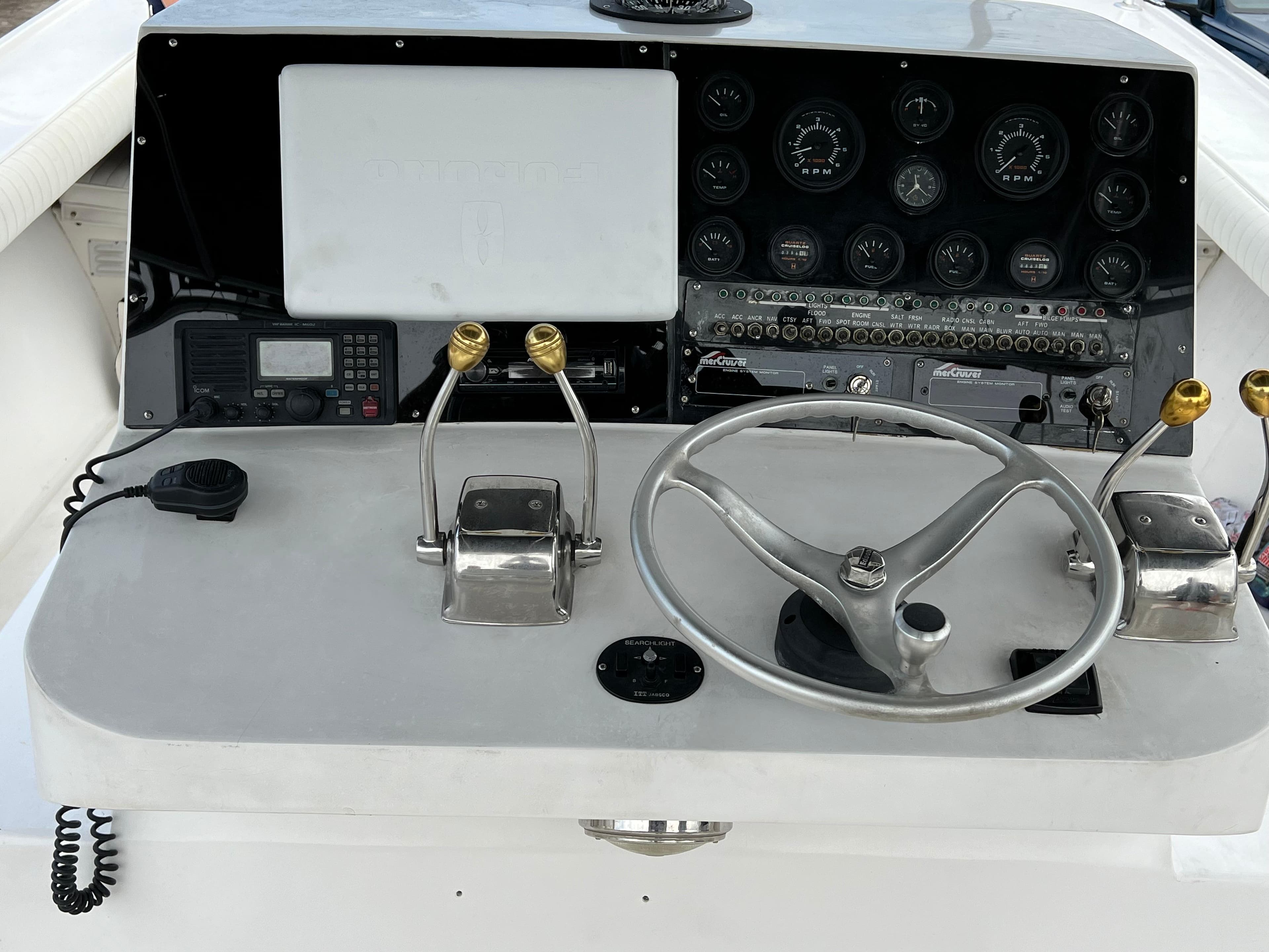 Control panel of a 2000 Stuart Angler 32 Center Console/Cutty boat with steering wheel and gauges.