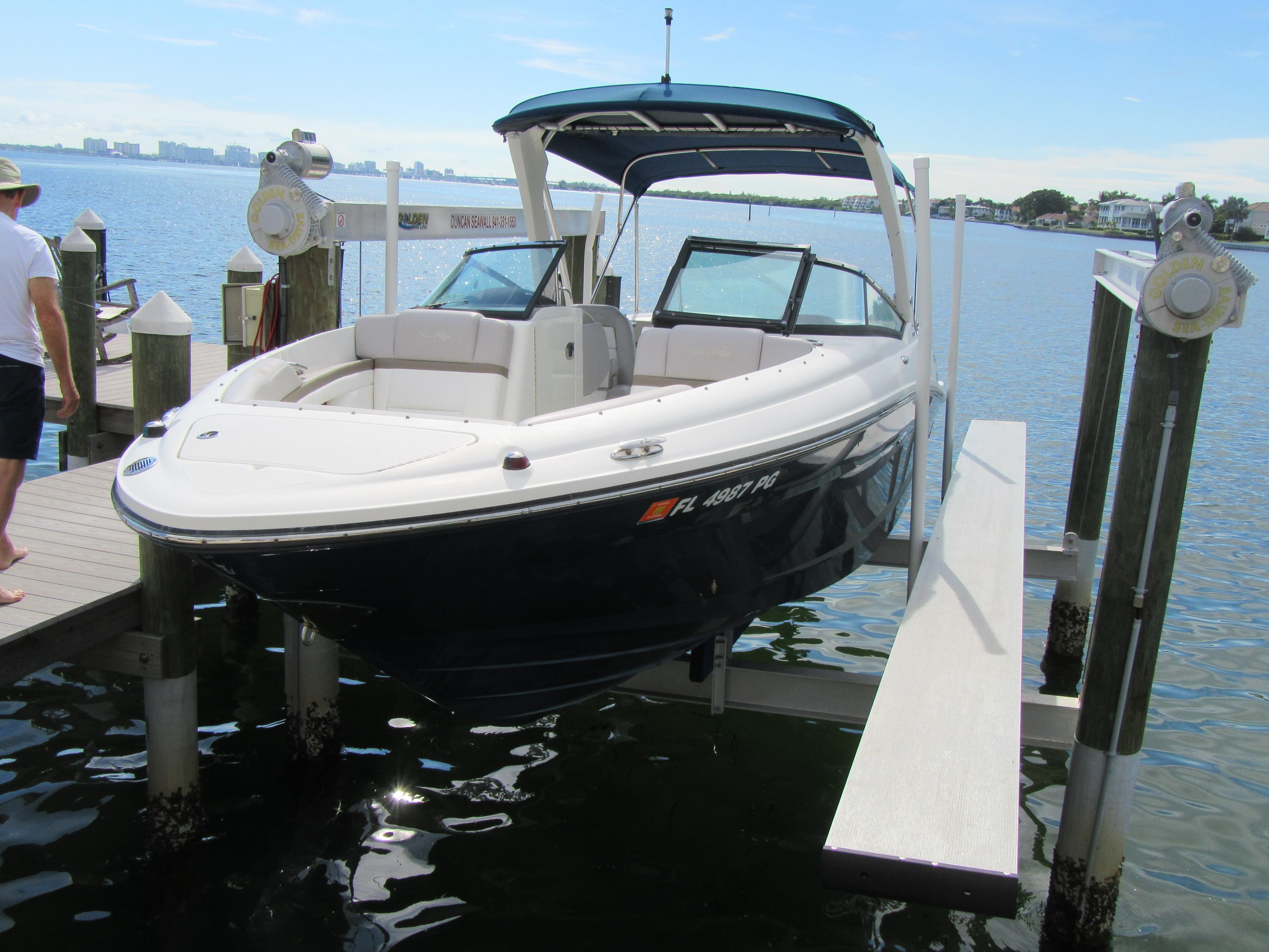2011 Sea Ray 250 SLX boat docked on a lift by the water.