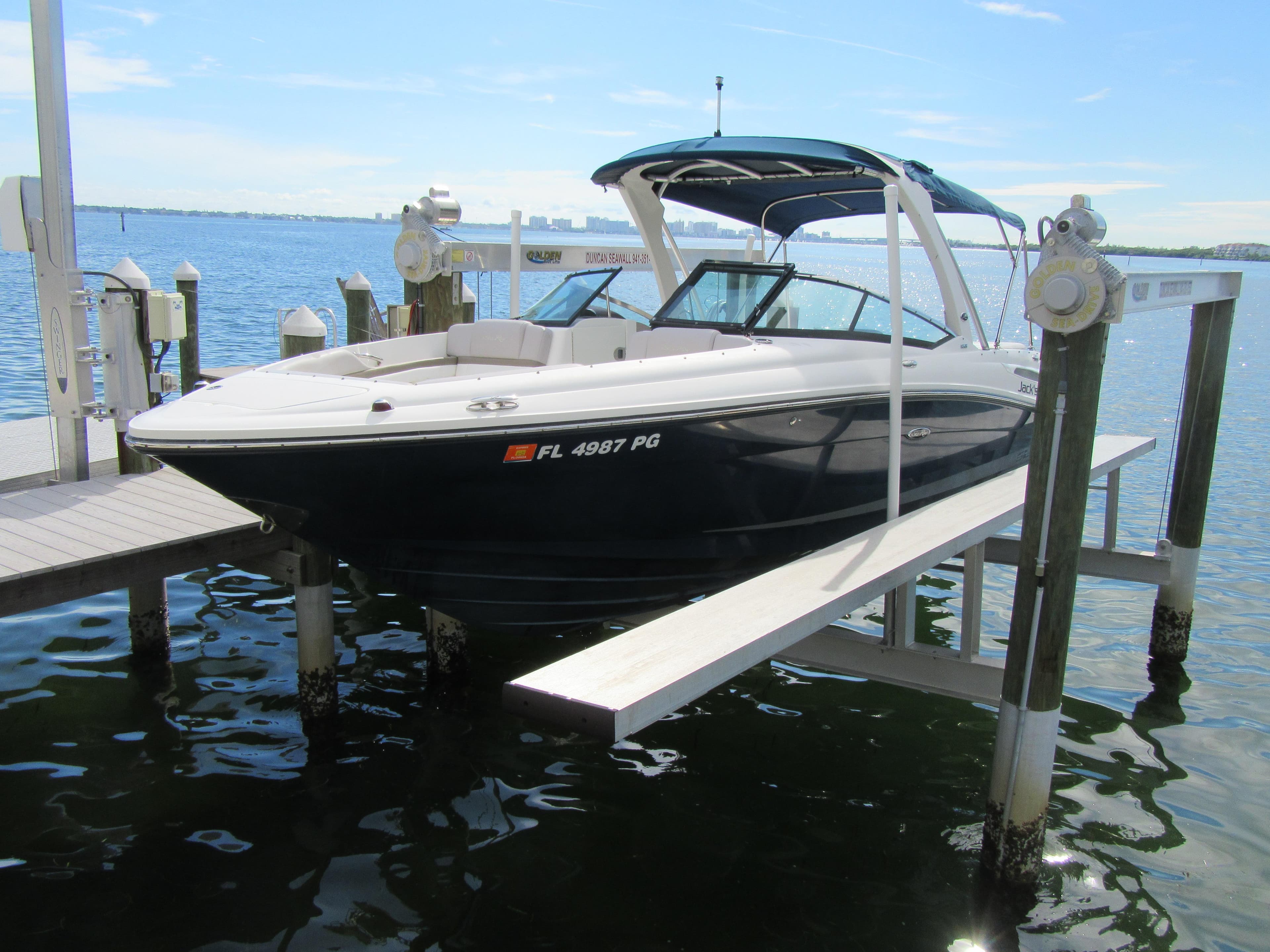 2011 Sea Ray 250 SLX boat docked on a lift by the water.