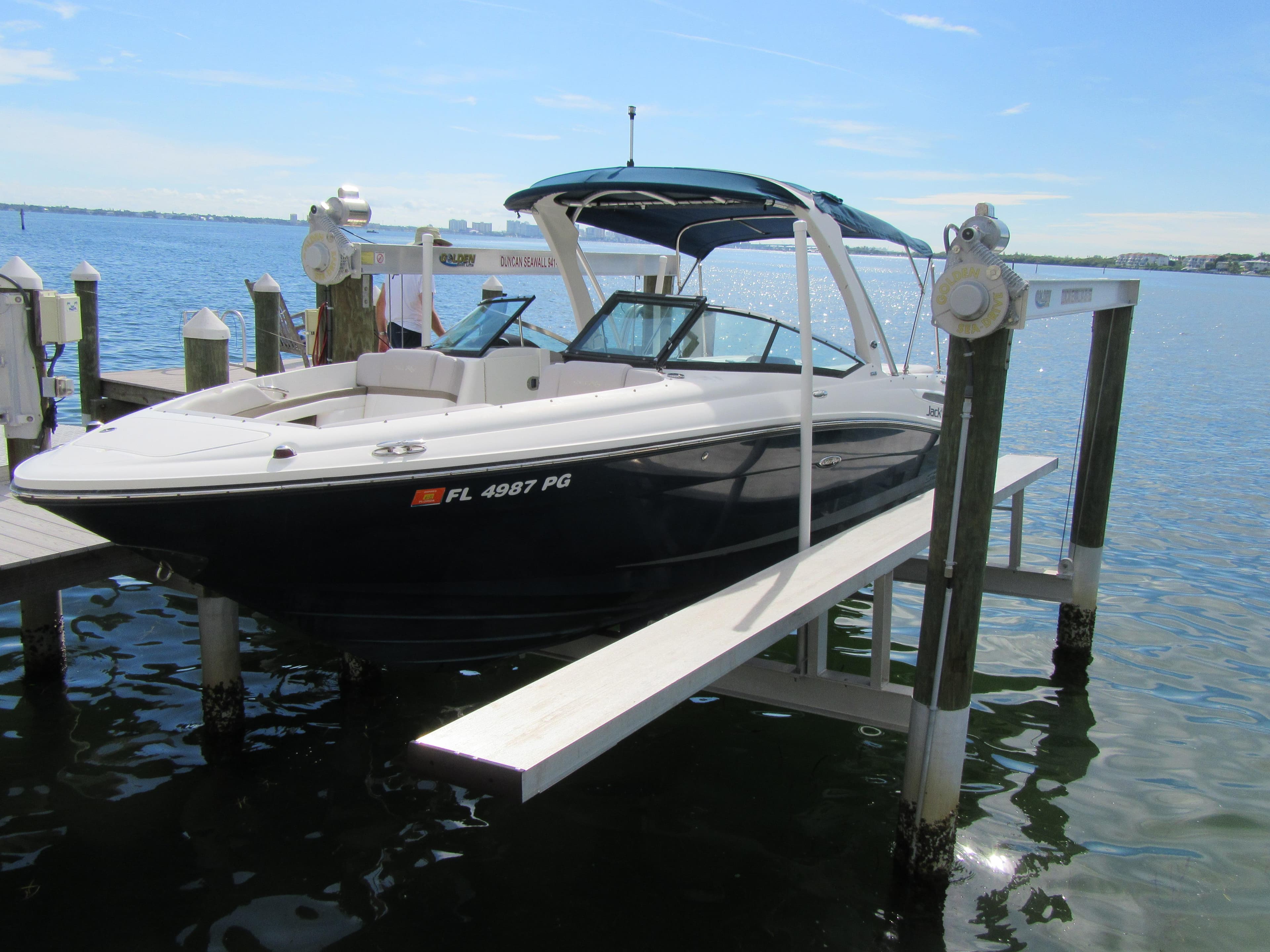 2011 Sea Ray 250 SLX boat docked on a lift by the water.