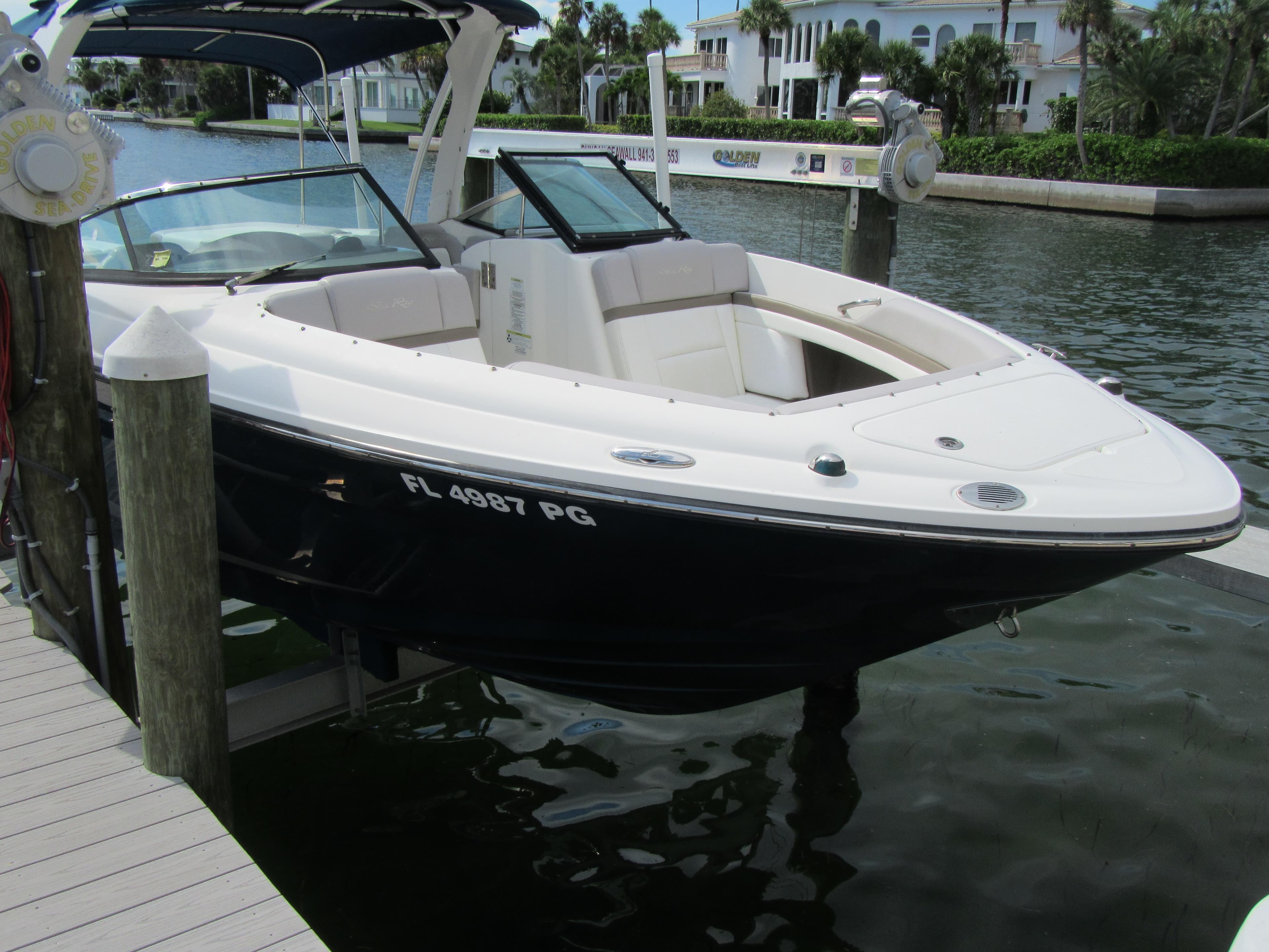 2011 Sea Ray 250 SLX boat docked on a sunny waterfront.