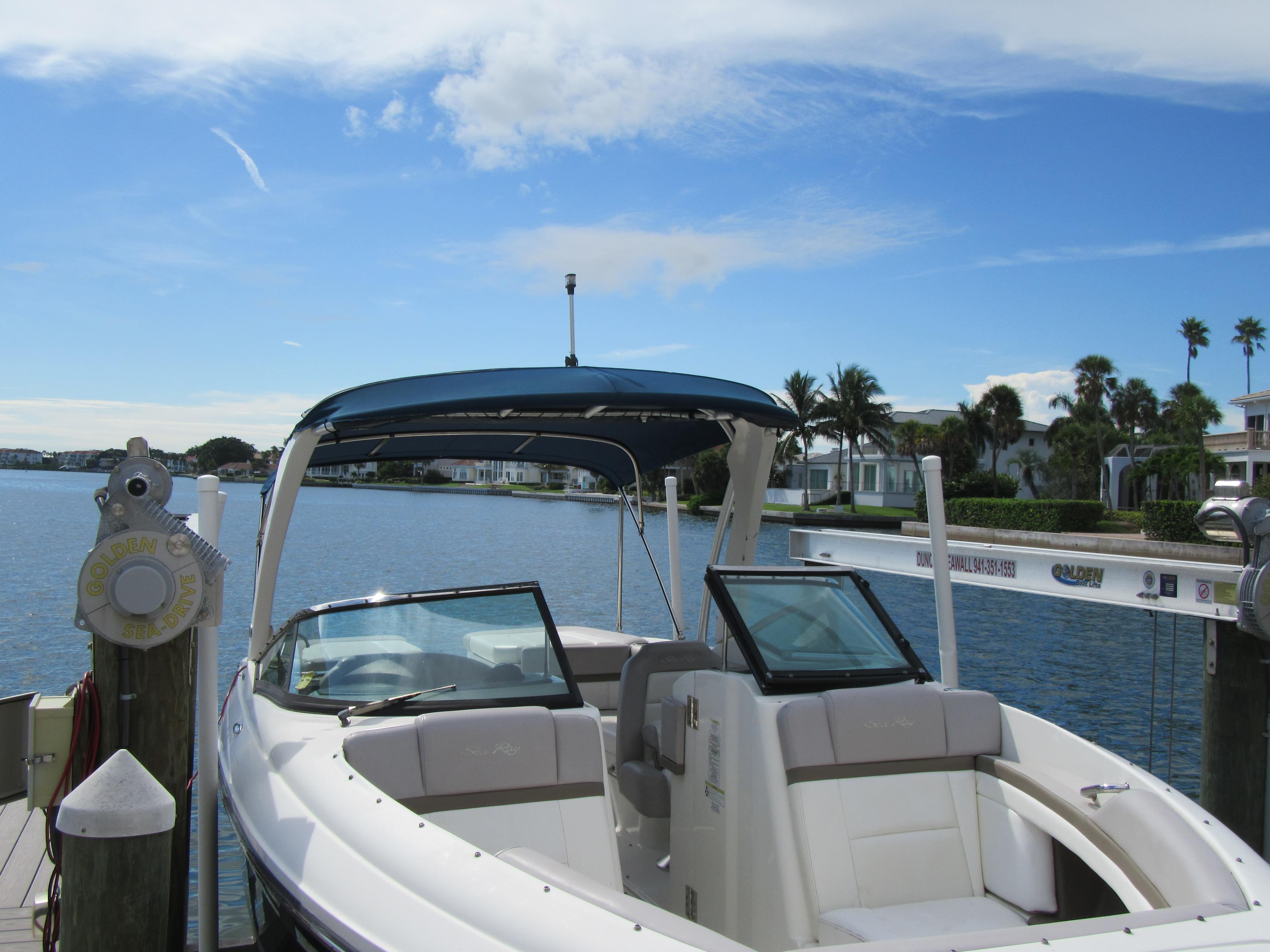 2011 Sea Ray 250 SLX boat docked by a scenic waterfront with clear skies.