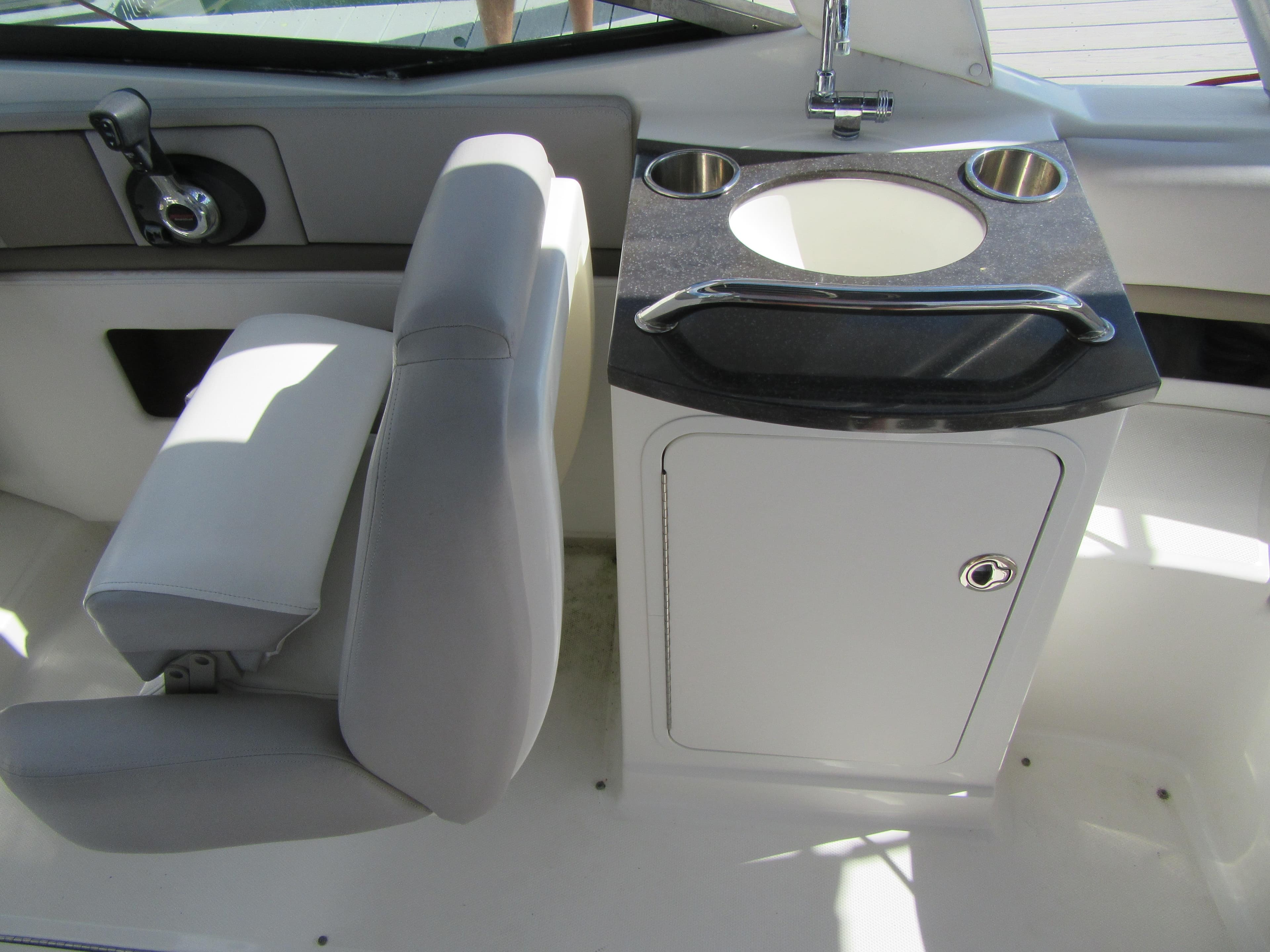 Interior of 2011 Sea Ray 250 SLX boat with seat and sink area.