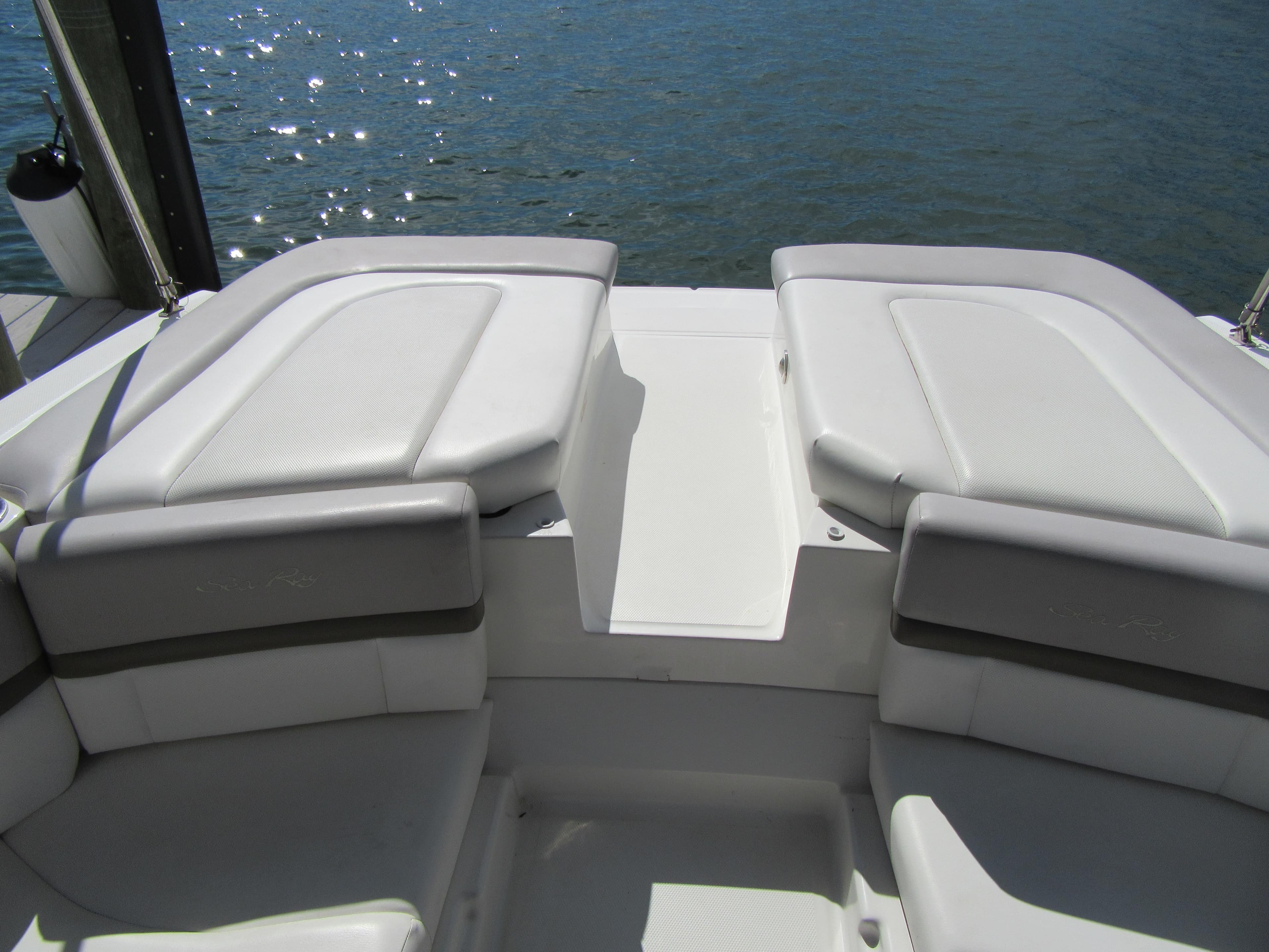 2011 Sea Ray 250 SLX boat interior with cushioned seating by the water.