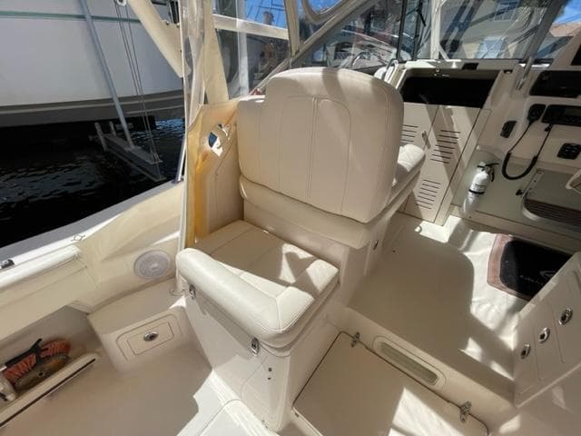 2017 Grady-White 300 Marlin boat interior with white captain's chair and control panel.