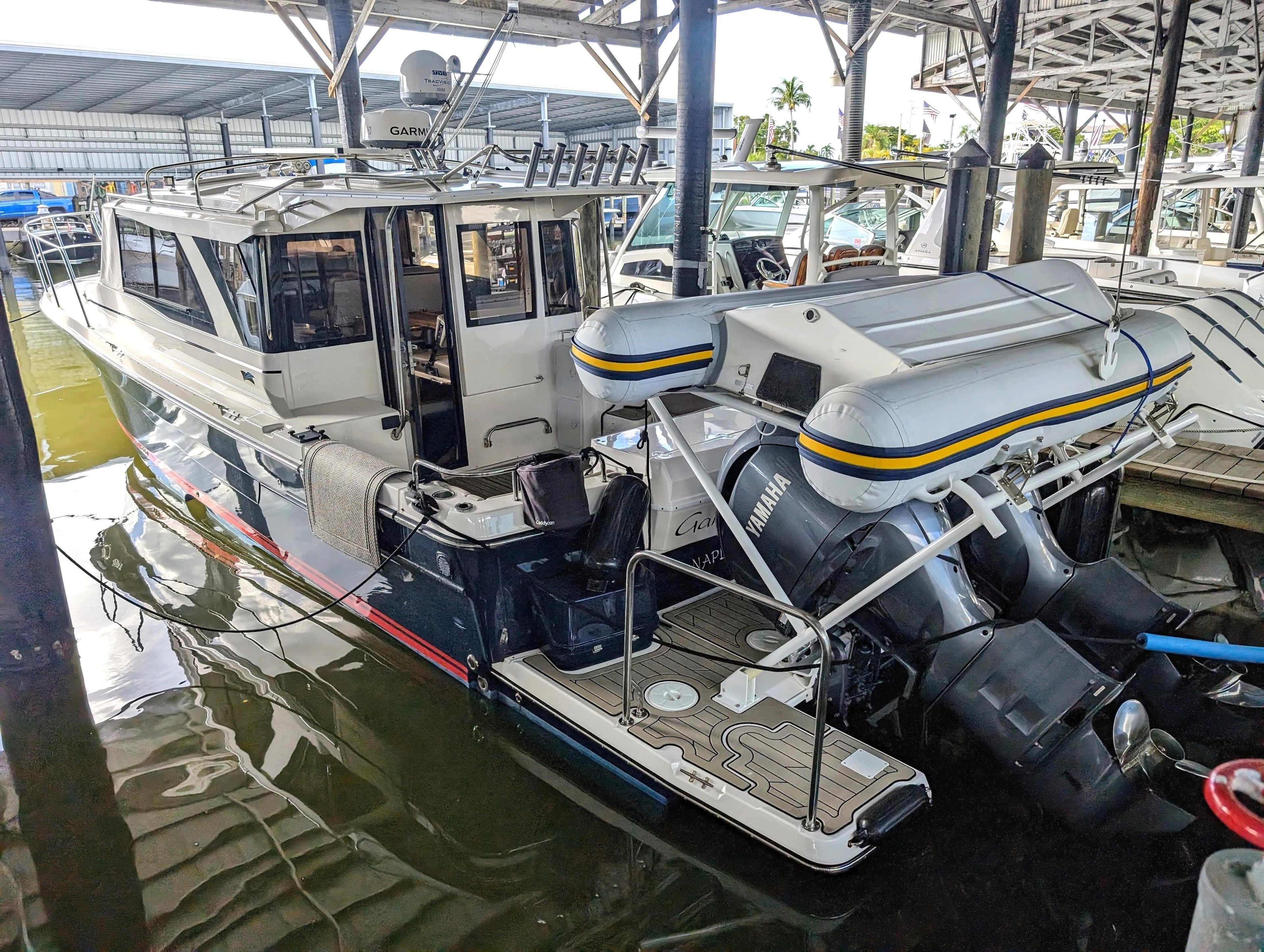 2022 Cutwater C-32 Coupe LE docked with inflatable boat and Yamaha outboard motors.