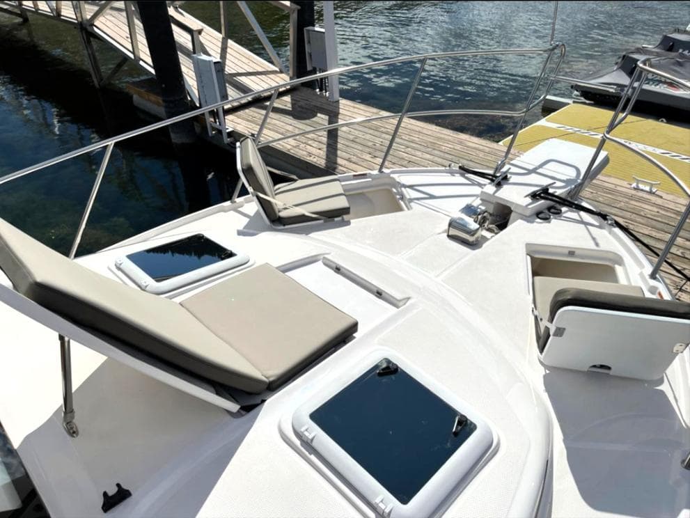 2022 Cutwater C-32 Coupe LE boat with sun loungers and deck hatches at the dock.