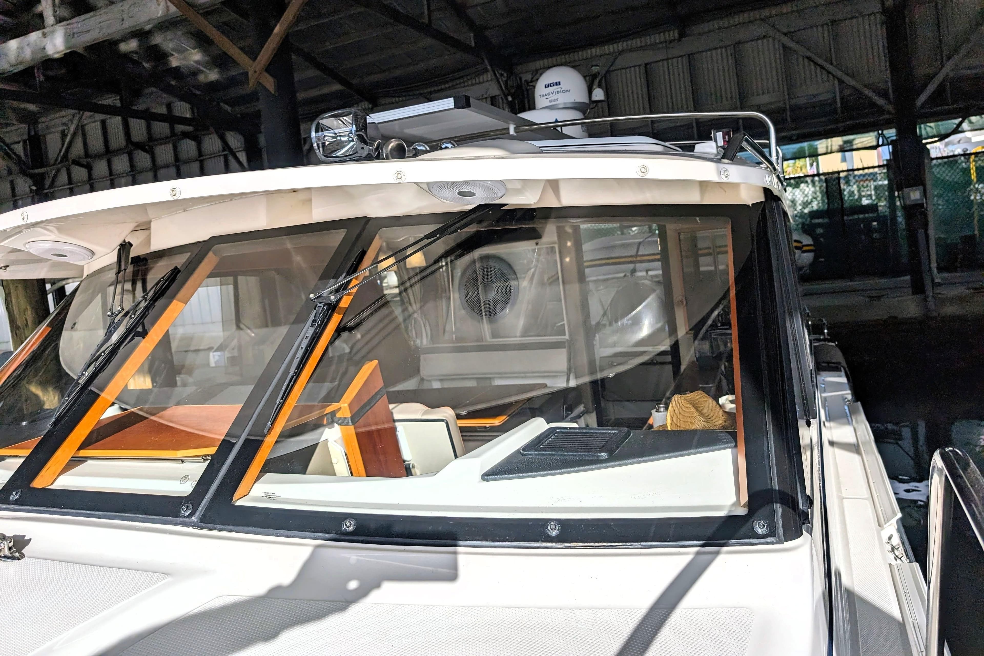 2022 Cutwater C-32 Coupe LE boat docked under a covered structure.