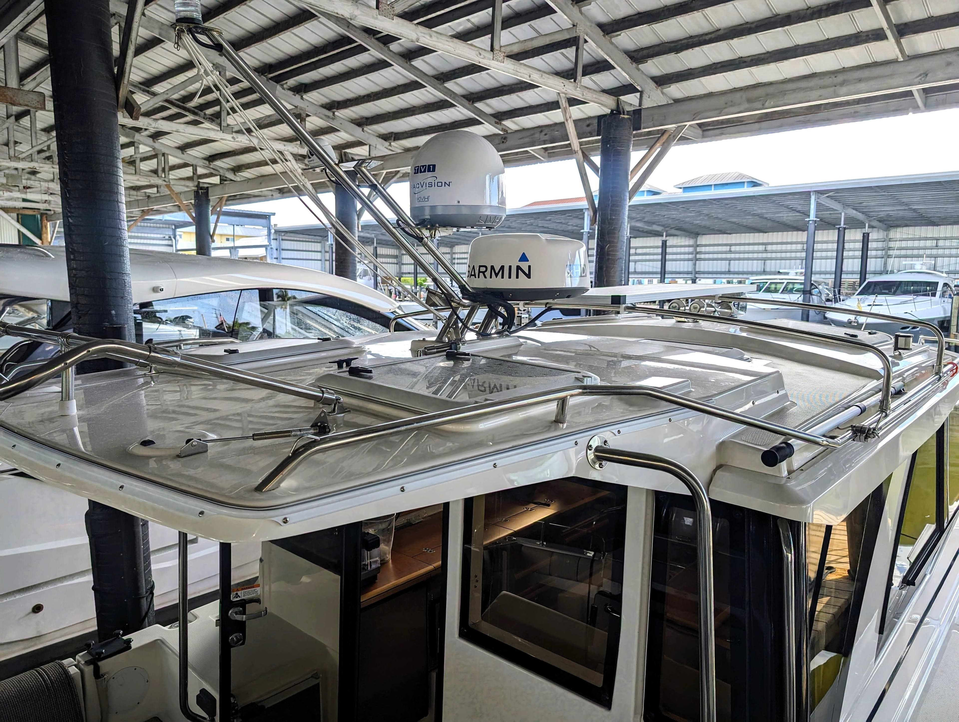 2022 Cutwater C-32 Coupe LE boat under covered dock with Garmin radar.