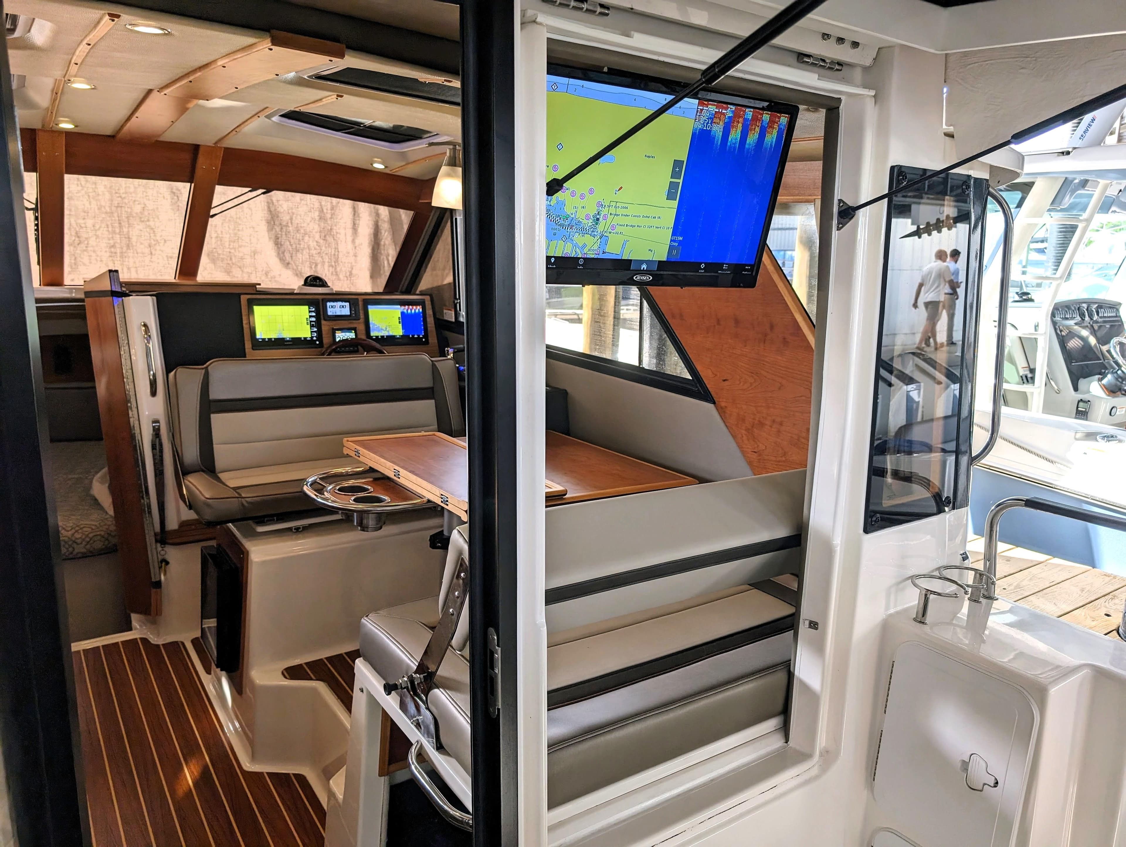 Interior of 2022 Cutwater C-32 Coupe LE with navigation screens and seating area.