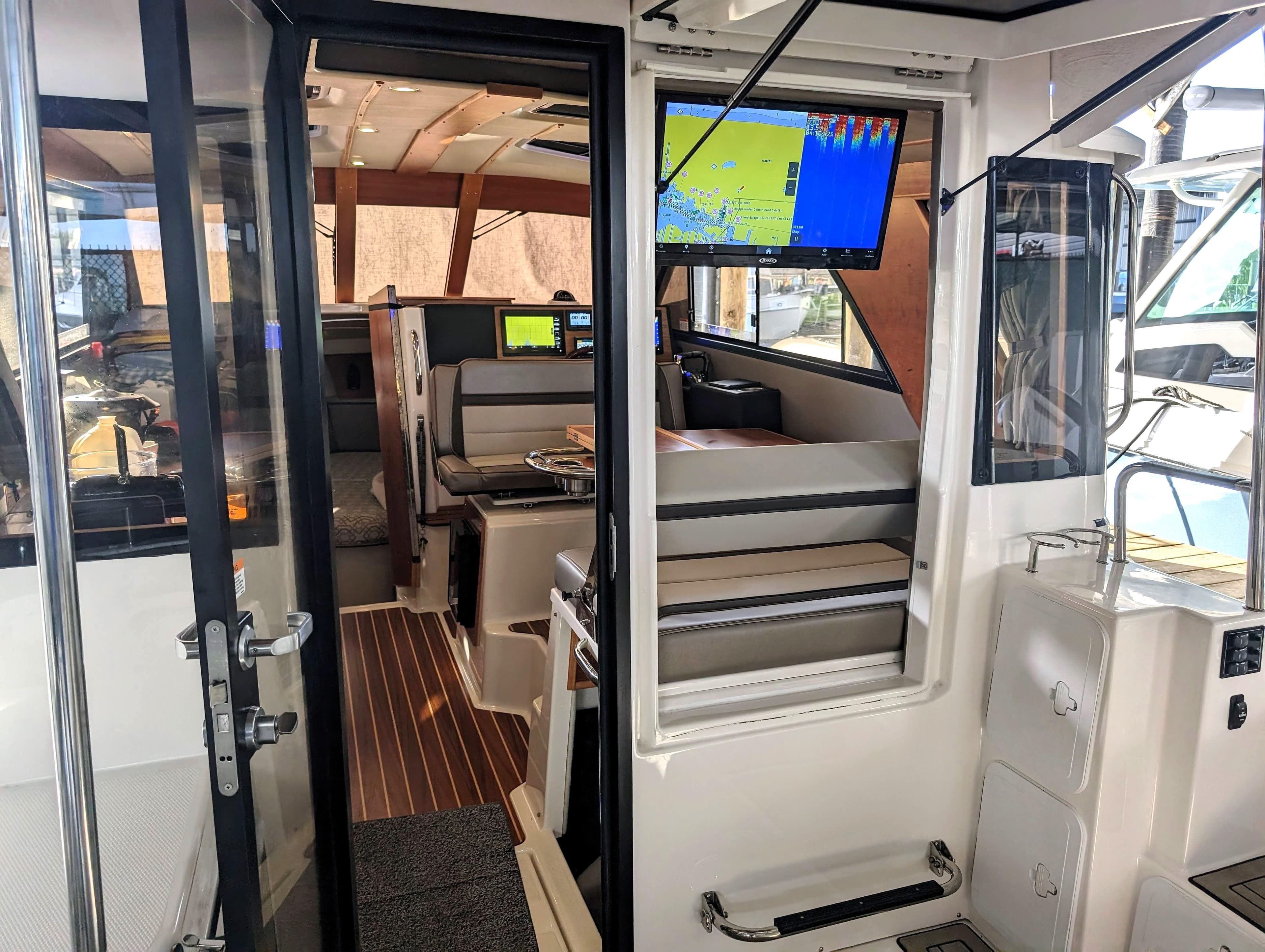 Interior of 2022 Cutwater C-32 Coupe LE boat with navigation screens and seating area.