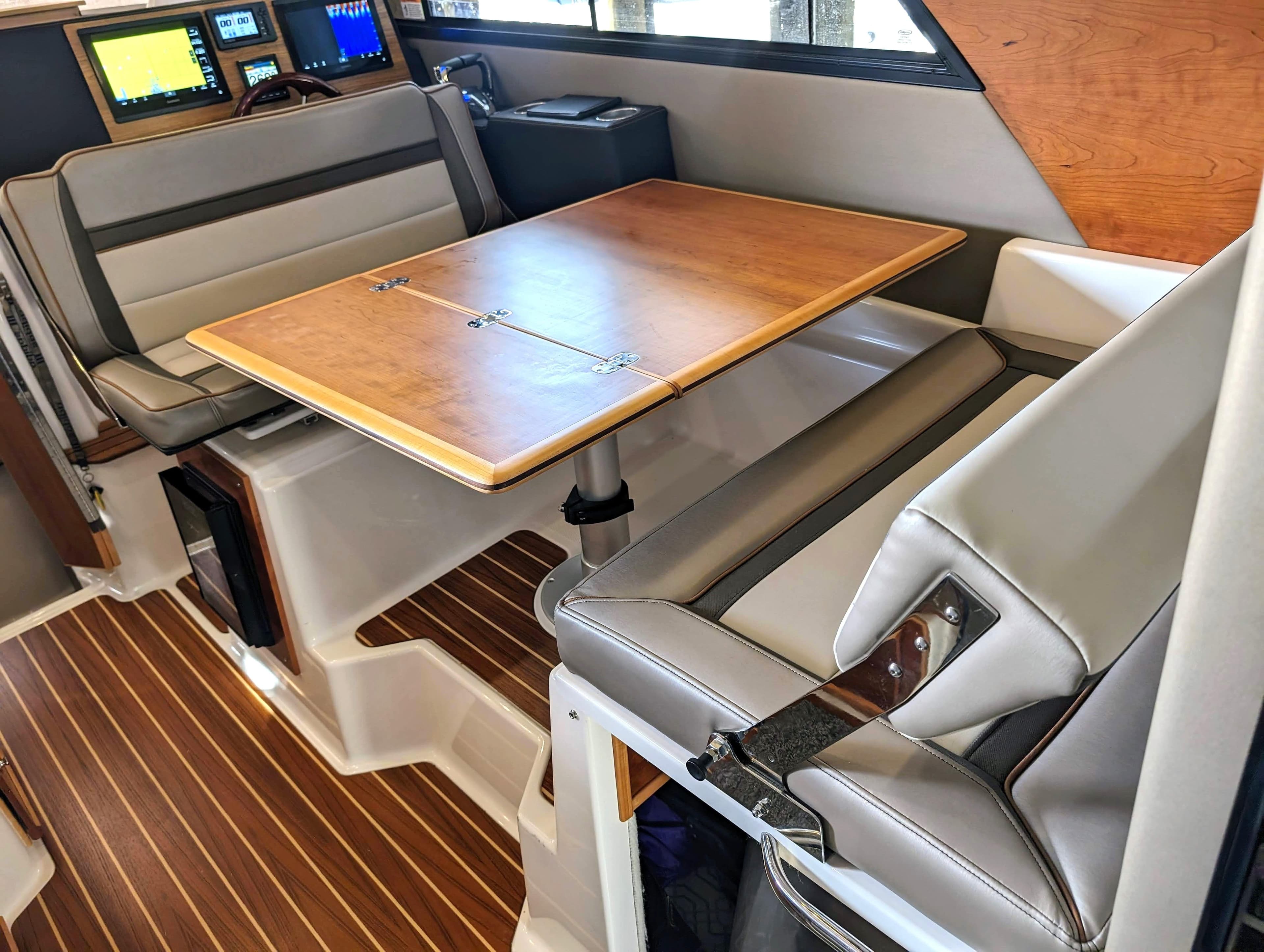Interior of 2022 Cutwater C-32 Coupe LE with dining table and seating.