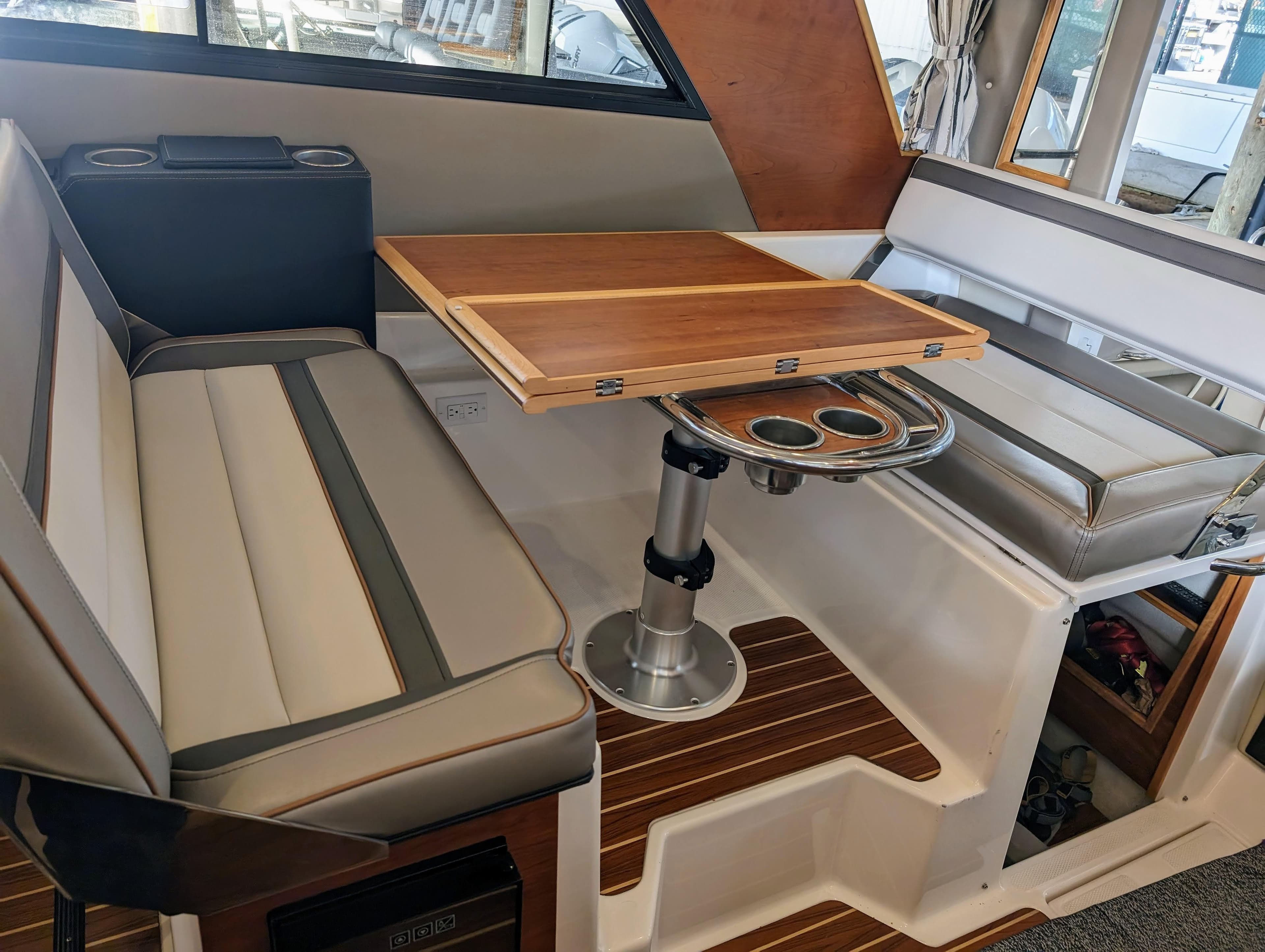 Interior seating and table of a 2022 Cutwater C-32 Coupe LE boat.